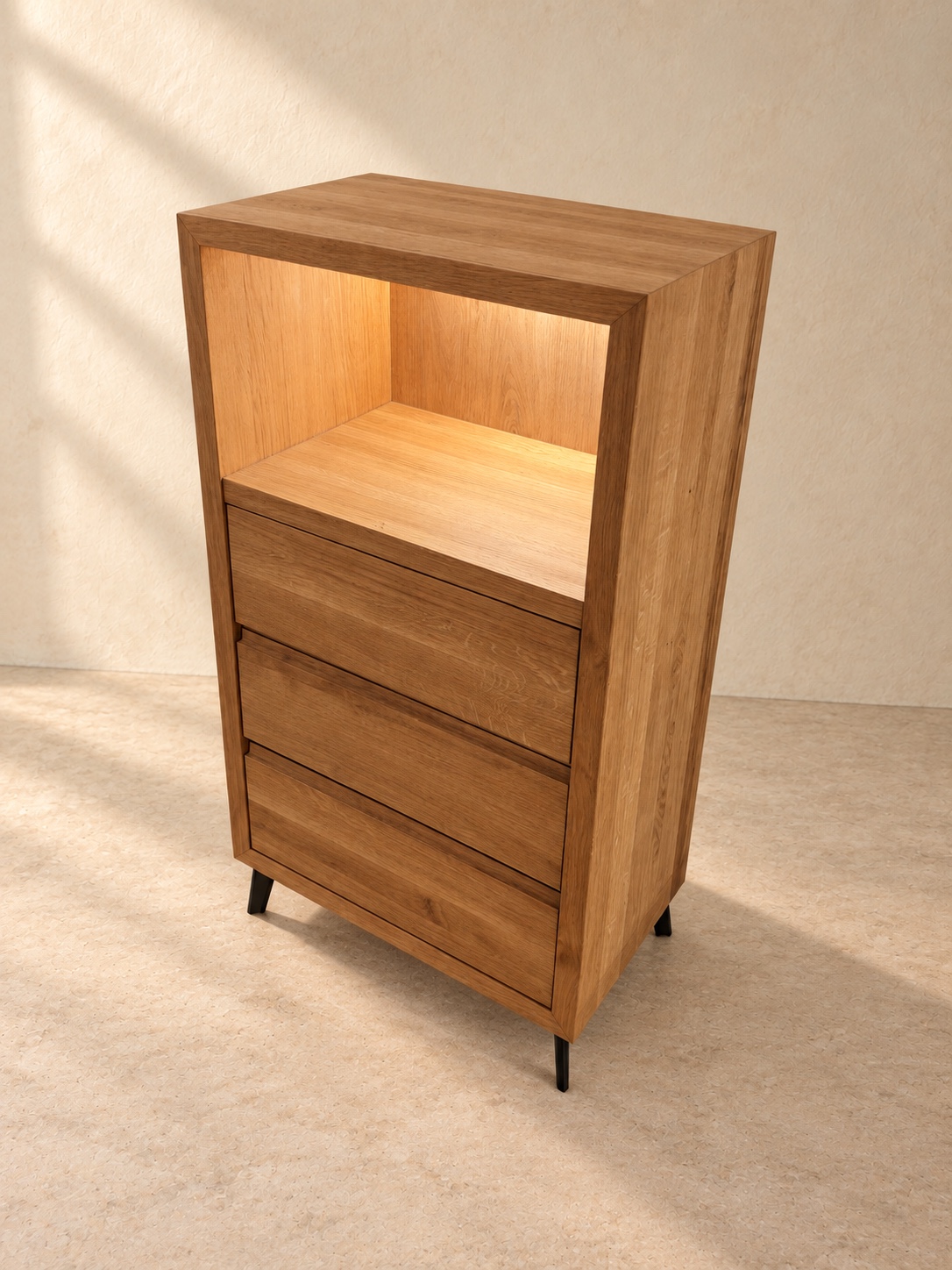 Holzkommode mit beleuchtetem offenem Fach, drei geschlossenen Schubladen und kurzen schwarzen Füssen, schräg von vorne.